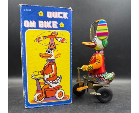 A Vintage 'Duck on a Bike' tinplate toy in box