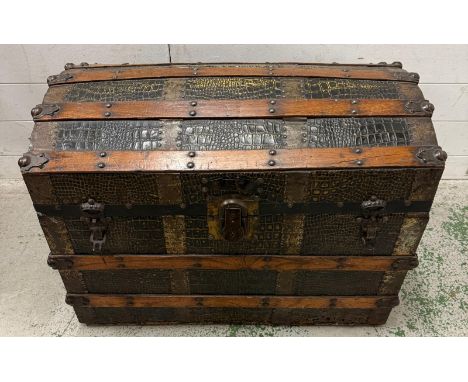 A Victorian steamer trunk, the chest with with its dome top and wooden and metal banding and faux crocodile skin effect (76CM