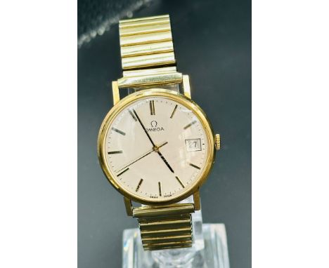 A gold Omega wristwatch, engraved to back