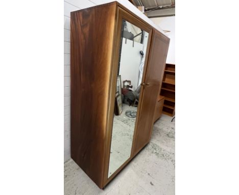 An Ercol style double wardrobe, the sliding mirrored door moves to reveal shelves and hanging rail to other side (H190cm W125