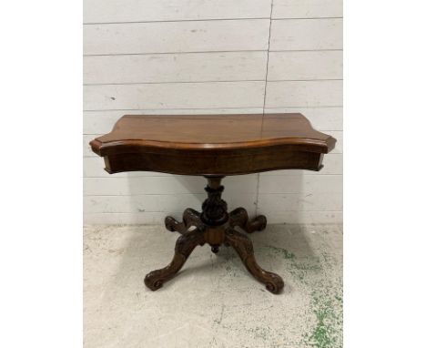 A Victorian burr walnut mahogany topped serpentine fronted games or card table on four heavily carved scrolling legs (H72cm W