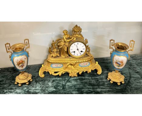 A gilt  bronze mantel clock with figural surmount, in set with serves style floral painted panels together with a pair of por
