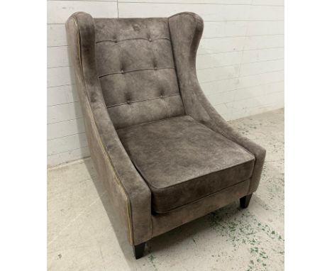 A contemporary button back wing back chair with gold piping. Width 80cm depth 90cm height 110cm