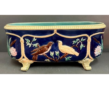 A Majolica planter, blue grounds with a bird and foliate relief on four scrolling feet (H19cm W45cm D22cm)