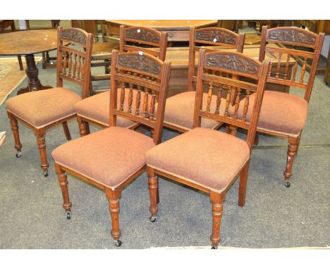 A set of six conforming Victorian dining chairs, carved to frieze, turned shaped slats, upholstered in light brown patterned 
