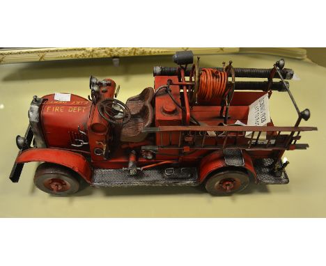 A metal model of a vintage Dennis fire engine.