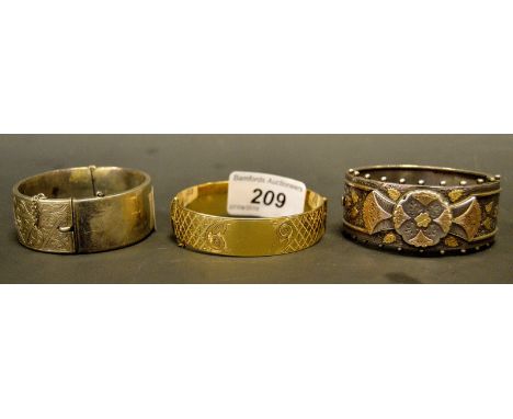 A silver hinged bangle; another;  a gold plated hinged bangle (3)