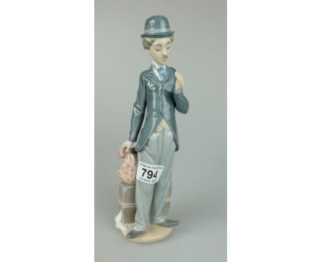 Charlie Chaplin with suitcase and travelling knapsack on the ground behind him height 28cm (missing flower and walking stick)