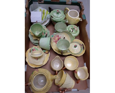 A collection of Carletonware cabbage pattern items in both green and yellow consisting of teapots, cups, saucers, dishes, pla