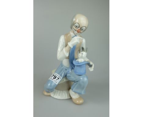 Roumano figure of Large clown seated on a pouffe holding a tophat with a smiling rabbit height 26cm