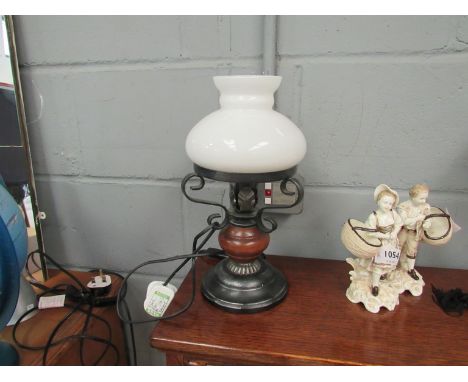 A table lamp as an oil lamp with white glass shade