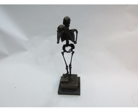 A bronze skeleton holding a skull, signed Carl Kayba on marble plinth, 33cm high