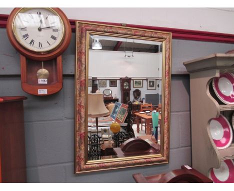 A bevel edged wall mirror with floral border