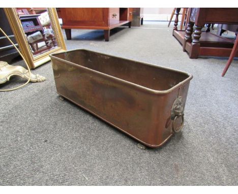 A copper planter with paw feet and lion head handles
