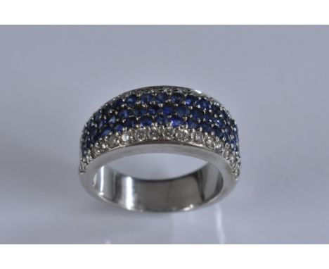 A sapphire and diamond ring, central cluster of forty nine round cut sapphire arranged in three rows, surrounded by a band of