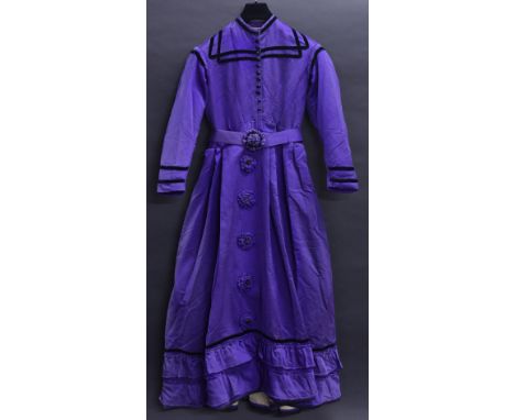 An Edwardian cotton button front day dress, purple, black velvet trim, rosette detail, belt featuring rear bow