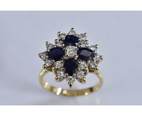 A sapphire and diamond flower head cluster ring, central round brilliant cut diamond approx 0.20ct, within a shaped quartetto