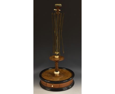 An early Victorian yew and ebonised tabletop woolwinder/seamstress's companion, pin cushion cresting above an expanding steel