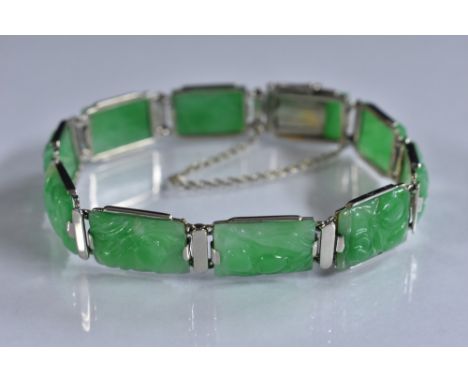 A Chinese carved jade ten panel bracelet, each rectangular panel relief carved with fruit, unmarked white metal frame, compre