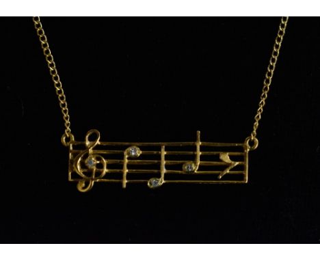 An unusual diamond accented four stone musical notes pendant necklace, 9ct gold body and chain, London 1978, 38cm long, 1.9g 