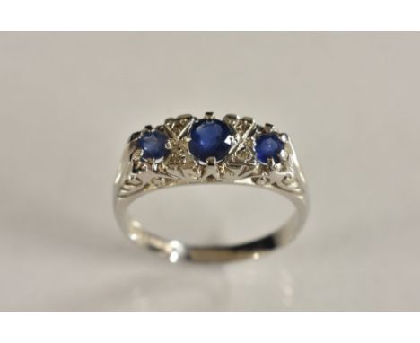 A diamond and blue spinel seven stone panel ring, three graduating blue spinel's, each divided by a pair of diamond accents, 