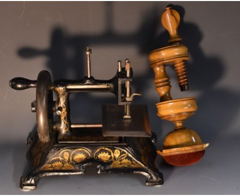 A late 19th Century miniature sewing machine, black cast iron, gilt Art Nouveau style water lily decoration, marked Made in G