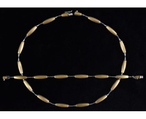 A 9ct yellow and white gold necklace and bracelet suite, each with textured yellow gold arched bars, inter spaced with white 
