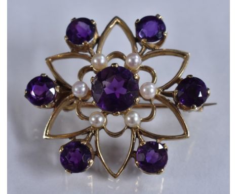 A 9ct amethysts and seed pearl floral cluster brooch, open six point star body, each petal divided by a round cut amethyst, s