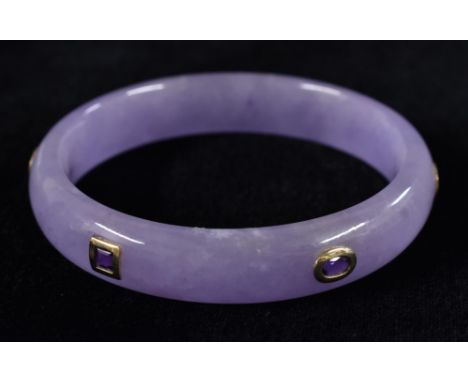 A lavender jade bangle, inset with six oval, round and square cut amethysts, each 14ct gold collar set, unmarked, 74mm diamet