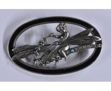 An Art Nouveau style silver and enamelled oval brooch, cherub riding a dragon fly, turquoise and paste set tail and eye, with