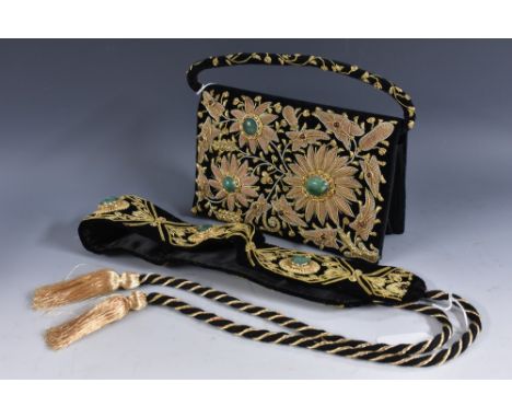 An Indian velvet evening purse, heavily embroidered, set aventurine and ruby, conforming belt, tie fastening
