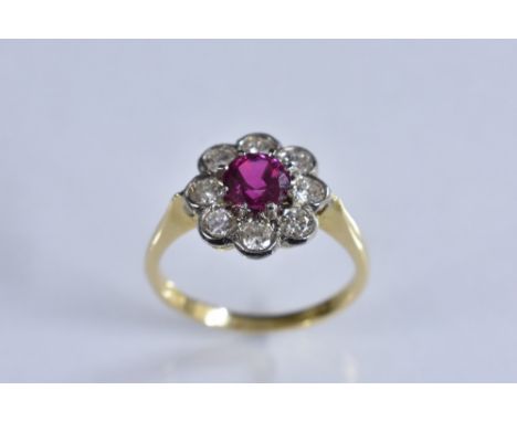 A ruby and diamond flower head cluster ring, central round pinky red ruby approx 0.87ct, surrounded by eight round old brilli