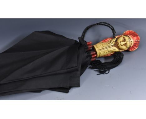 An Art Deco novelty umbrella, the tinted ivorine handle in the form of a double headed Indian chief