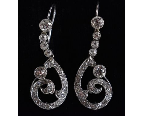 A pair of Art Deco diamond encrusted scrolling drop earrings, total estimated diamond weight approx 1.70ct, unmarked white me