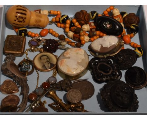 A selection of vintage jewellery including carved mourning brooches, conche shell cameos in pinchbeck surrounds, glass locket