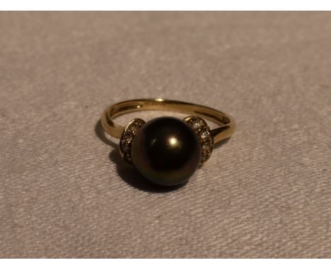 A lady's dress ring having a simulated black pearl flanked by cubic zirconias on a 14ct gold loop, size R &amp; 3.5g