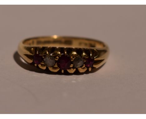 A lady's dress ring having a trio of rubies interspersed by two old cut diamonds in a gallery mount on an 18ct gold loop, siz