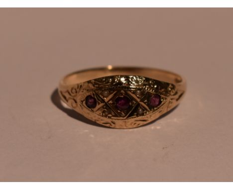 A lady's dress ring of shaped band form having ruby and seed pearl decoration to engraved panel on a 9ct gold loop, size Q &a