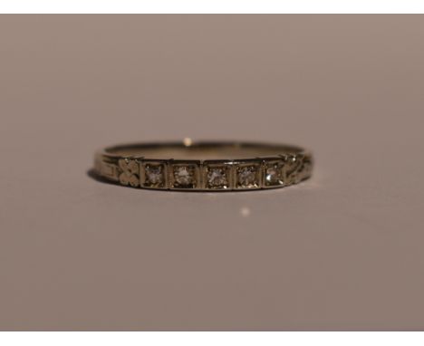 An American Orange Blossom white metal band ring stamped 18k by TRAUB having four inset diamond chips and engraved/moulded sh