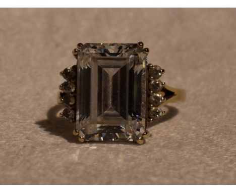 A lady's dress ring having a baguette cut cubic zirconia flanked by two rows of four round cut CZ to open shoulders on a 14ct