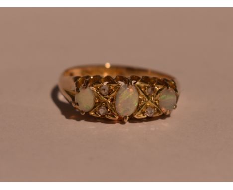 A lady's dress ring having three graduated opals interspersed by diamond chips in a gallery mount on an 18ct gold loop, size 