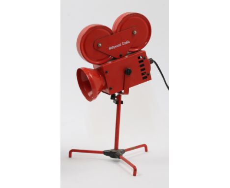 A novelty red metal table lamp designed as a Hollywood Studios film projector, on tripod base, approx. 34cm highIt is the buy