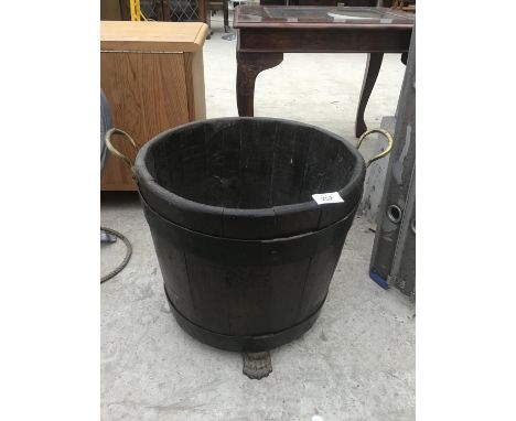 A WOODEN HALF BARREL STYLE PLANTER WITH BRASS HANDLES AND FEET 