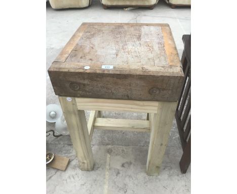A BUTCHERS BLOCK ON A STAND 
