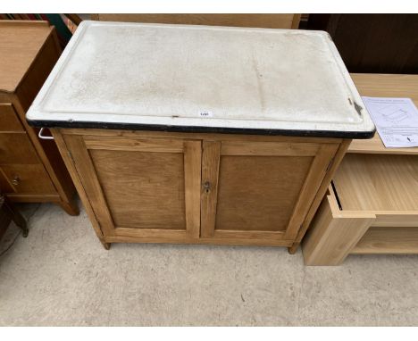 A PINE KITCHEN CABINET WITH TWO DOORS AND ENAMEL TOP 