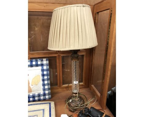 A DECORATIVE LAMP BASE AND SHADE WITH GLASS COLUMN 