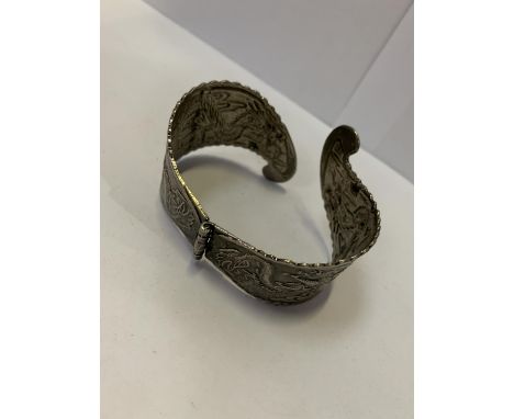 AN ORIENTAL STYLE WHITE METAL BANGLE 