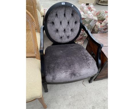 A BLACK FRAMED NURSING CHAIR WITH GREY UPHOLSTERED SEAT AND BUTTON BACK.THIS CHAIR COST £1300 AT A TRADE SHOW AS THE FABRIC W