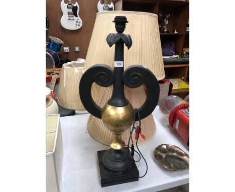 A BLACK AND GOLD LAMP BASE TOGETHER WITH TWO SHADES 