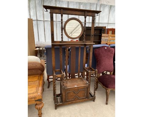 AN OAK HALL STAND WITH CENTRE CIRCULAR MIRROR AND BARLEY TWIST COLUMNS 